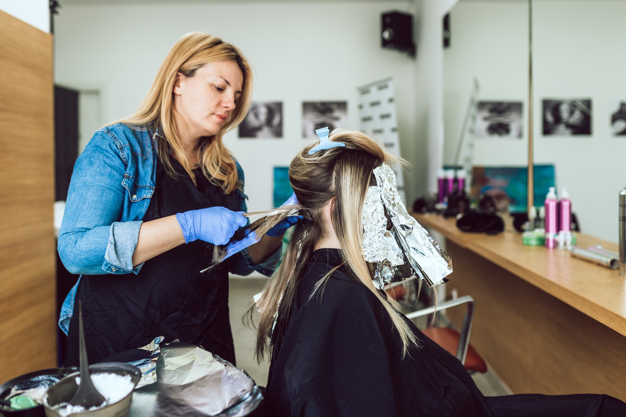  Cabeleireira aplicando mechas loiras em cliente em salão de beleza