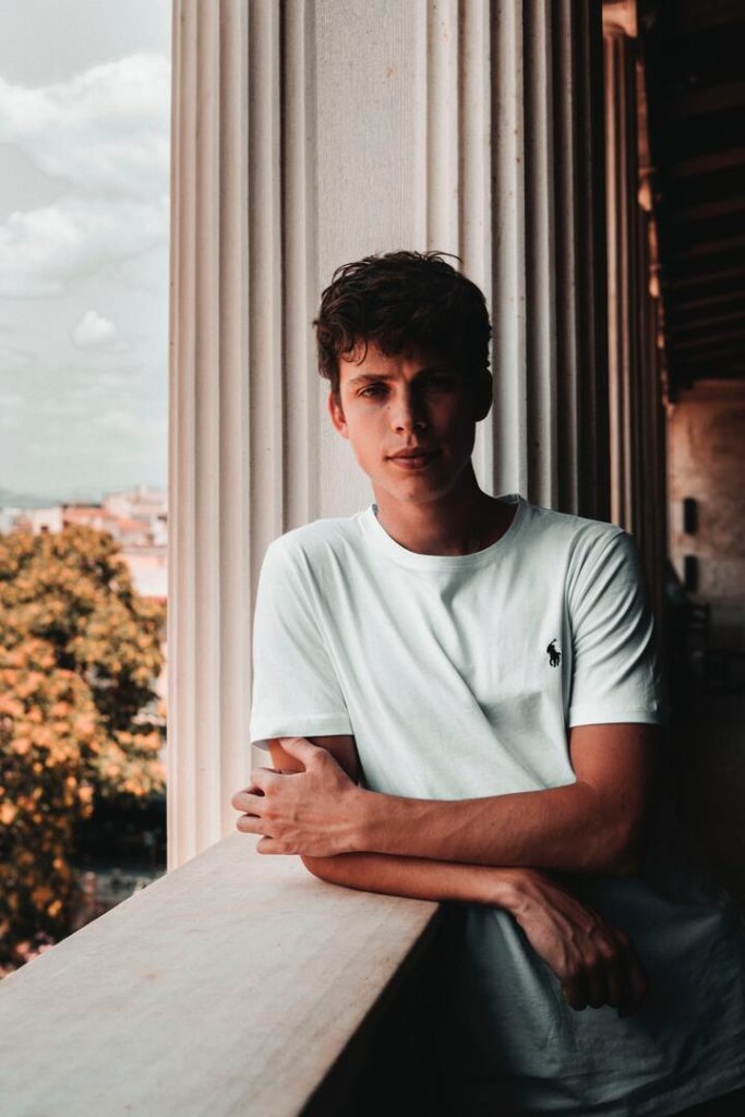 homem branco com cabelo ondulado e camiseta branca
