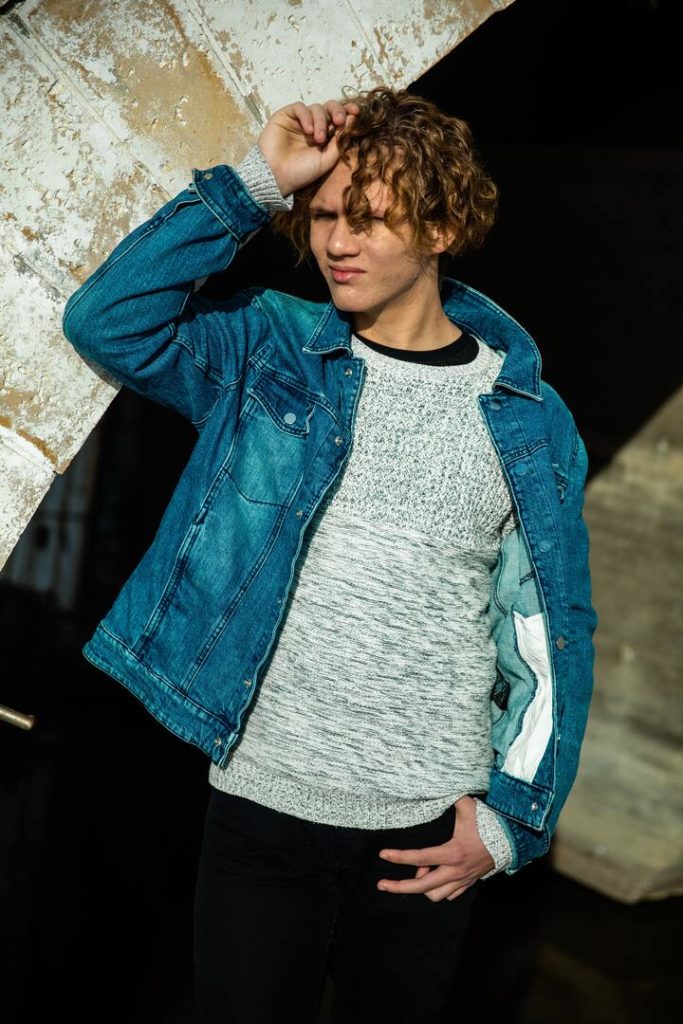 homem branco com cabelo ondulado e jaqueta jeans