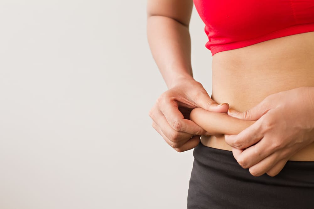  Mulher apertando a barriga flácida