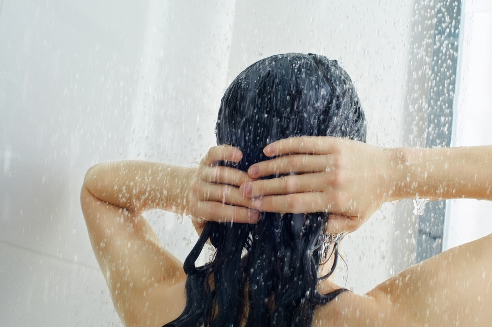  Mulher lavando o seu cabelo liso castanho escuro