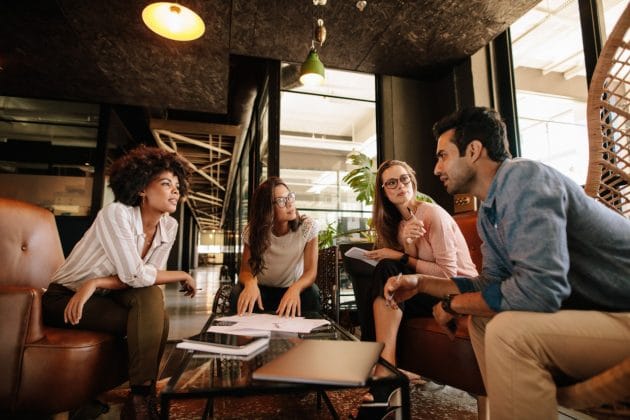  Grupo diversificado de colegas discutindo projeto em ambiente de escritório moderno