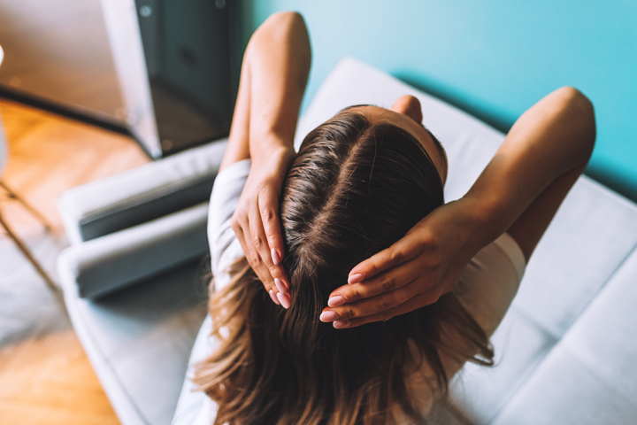 mulher passando as mãos no cabelo escuro
