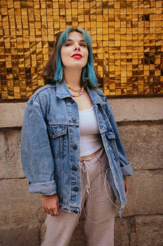 Mulher de cabelo curto, liso e castanho, com mecha frontal azul