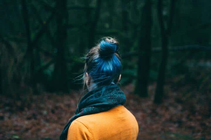 Mulher de coque, com o cabelo pintado de azul na nuca