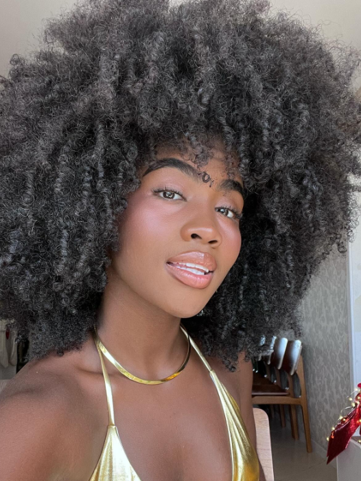 mulher negra de cabelo black power usado biquini dourado
