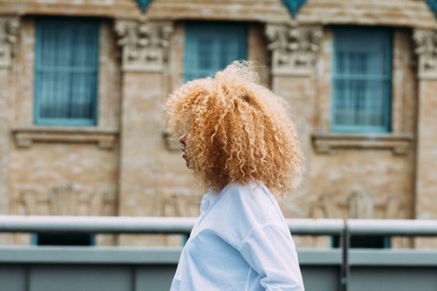 Mulher com cabelo cacheado descolorido
