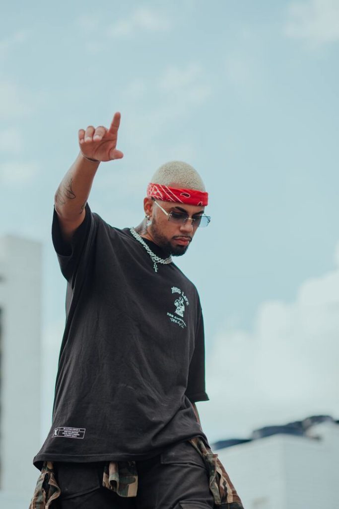 homem negro com bandana vermelha e mão para o céu