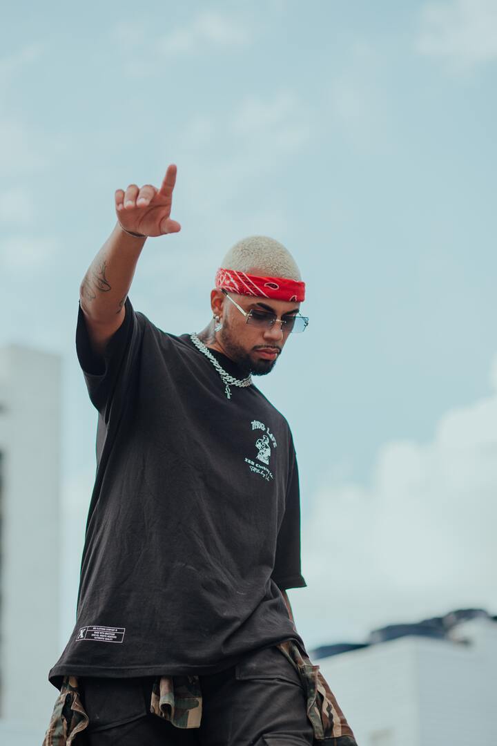  homem negro com bandana vermelha e mão para o céu