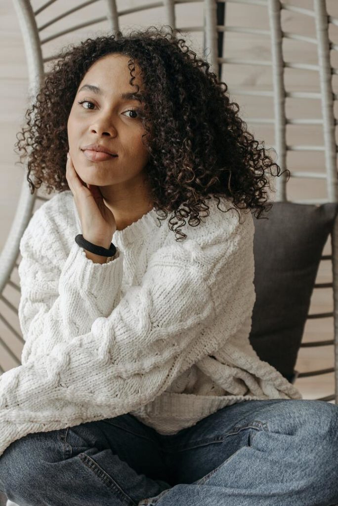 mulher negra de cabelos cacheados castanhos