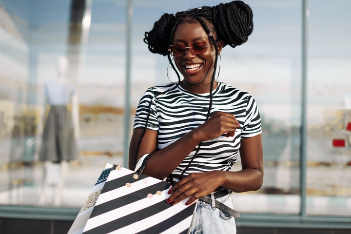 Mulher com tranças estilo dread, com penteado de coque duplo e baby hair