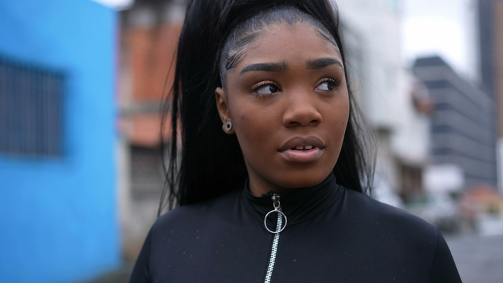 Mulher negra de cabelo liso longo, preso em um rabo de cavalo alto, finalizado com baby hair