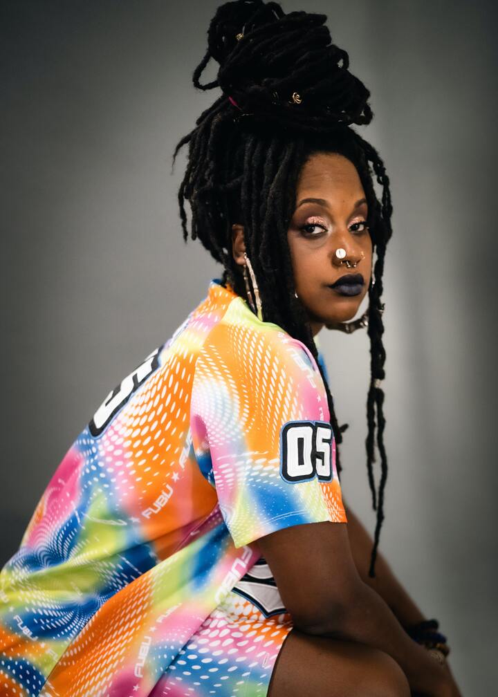 Mulher com dreads presos em um coque alto e despojado