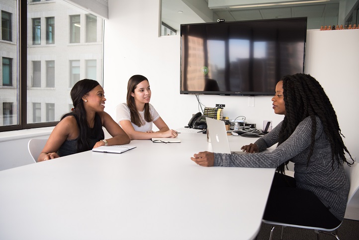  Três mulheres em uma sala de reunião, fazendo uma entrevista de emprego